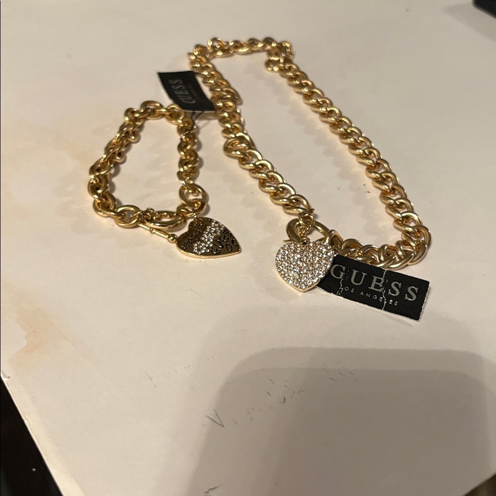 Goldtone Heart Charm Bracelet& Necklace with heart in rhinestones by Guess